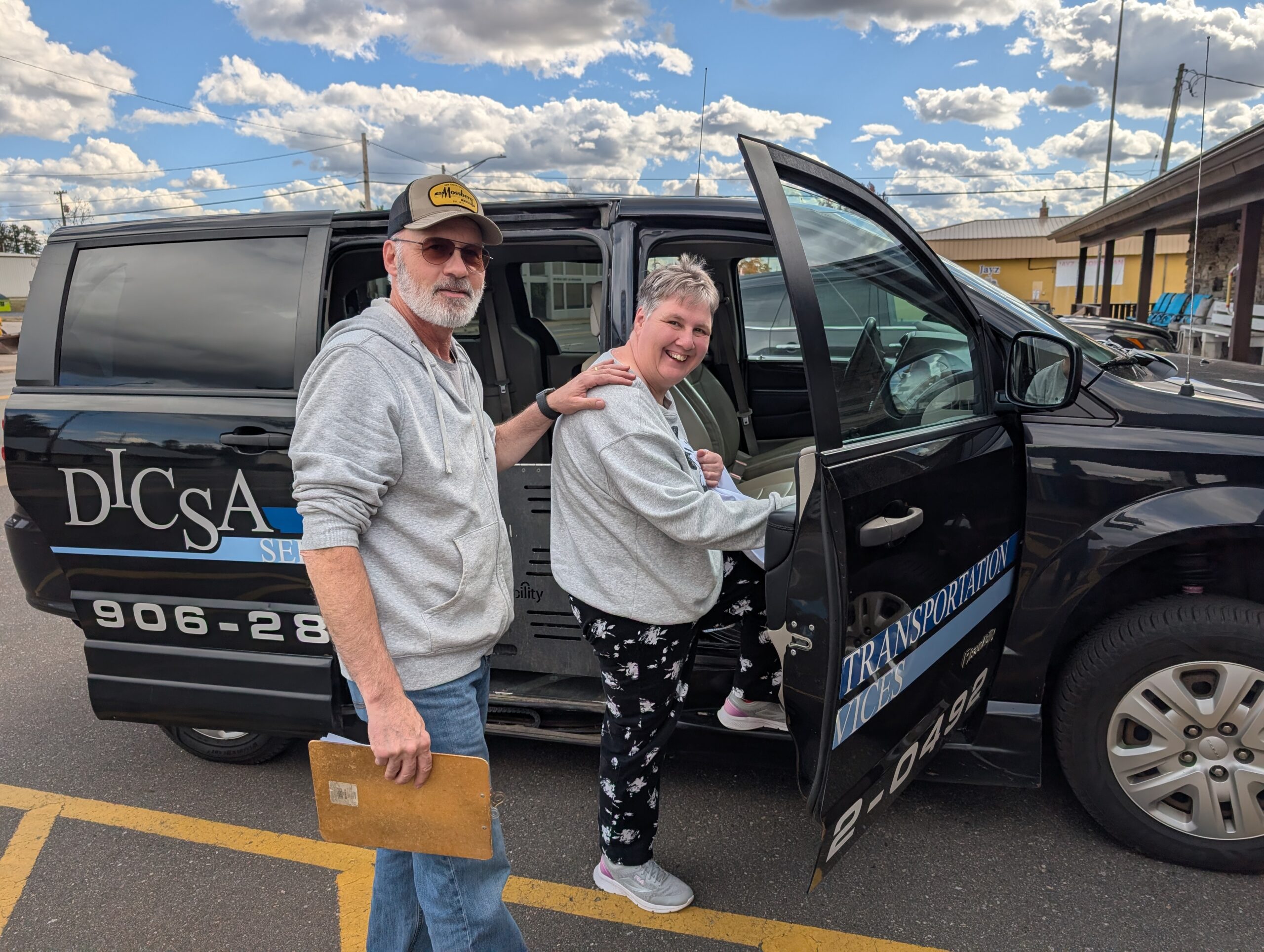 Transportation driver assisting a client into the van.